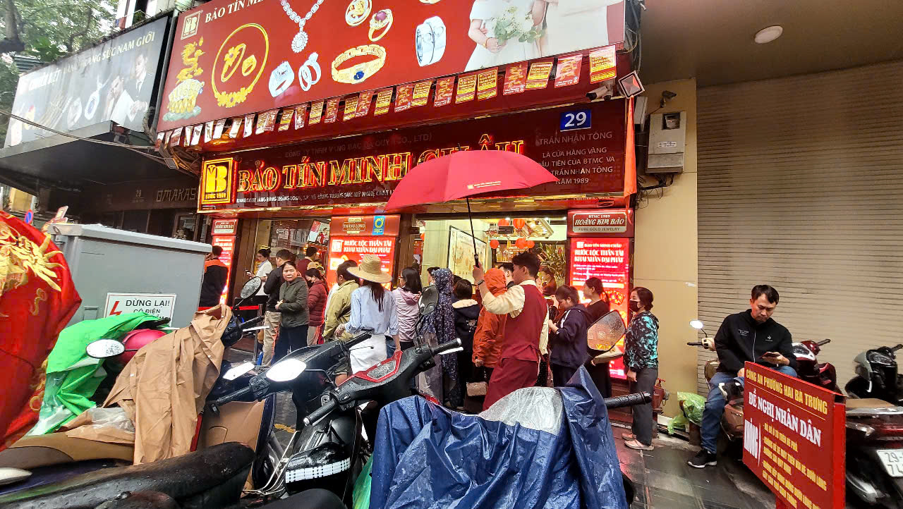 Người dân xếp hàng dưới mưa, chờ mua vàng trên đường Trần Nhân Tông, TP Hà Nội. Ảnh: LÊ THÚY