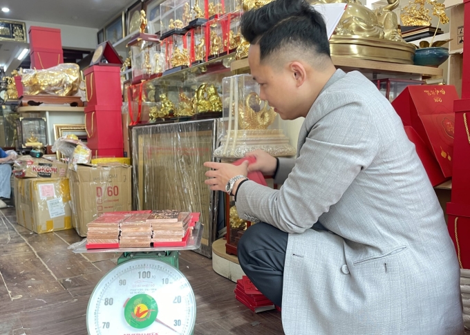 Một khách hàng đang mua đồng thỏi làm quà Tết cho nhân viên, hôm 28/1. Ảnh: Phan Dương